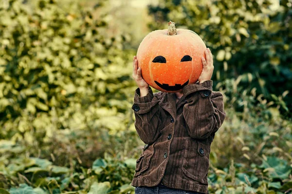 Menino segurando uma abóbora no Halloween — Fotografia de Stock