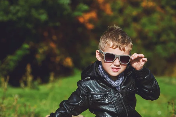 Porträt eines Jungen im Herbst Park an einem sonnigen Tag, ein kleiner Junge Modell posiert Fotograf — Stockfoto