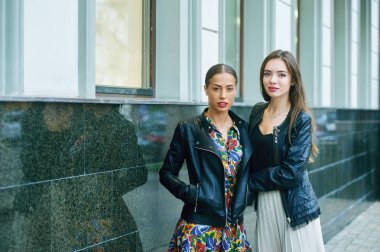 iki genç şık kadınlar sokakta giyinmiş.