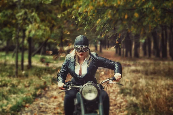 Aantrekkelijk meisje op een oude motorfiets in de herfst Park — Stockfoto