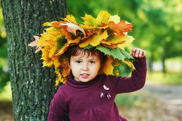 Portret dziewczynki z wieniec z liści jesienią Park — Zdjęcie stockowe