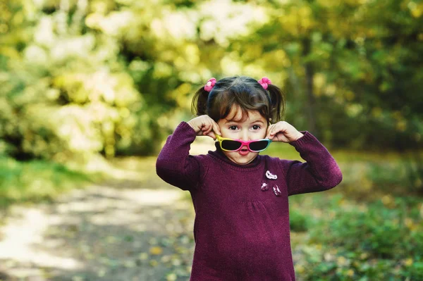 Смешная смешная девушка в солнечных очках в осеннем парке — стоковое фото
