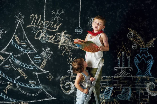 Dzieci udekorować choinkę. Brat i siostra narysować piosenki świąteczne na ścianie — Zdjęcie stockowe