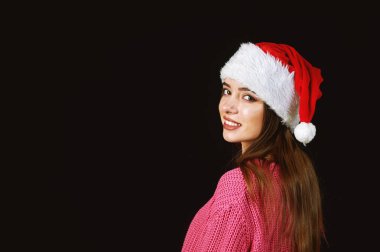 Santa şapka koyu arka plan üzerinde genç kadın