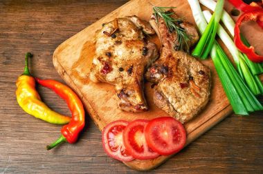 Koyu ahşap arka plan üzerinde sebze ile kemik üzerinde ızgara sulu biftek. 