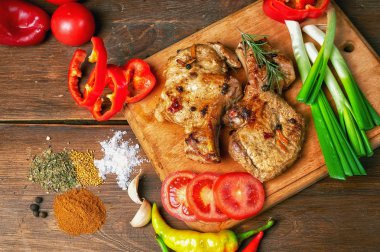 Koyu ahşap arka plan üzerinde sebze ile kemik üzerinde ızgara sulu biftek. 