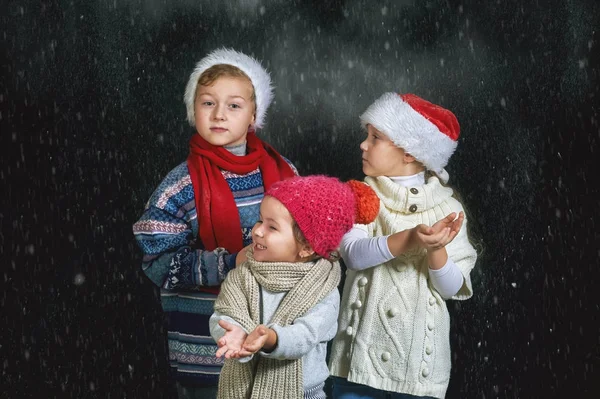 Crianças brincando com flocos de neve em um fundo escuro — Fotografia de Stock