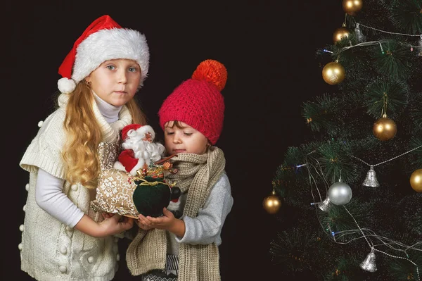 Τα παιδιά στολίζουν το χριστουγεννιάτικο δέντρο στο δωμάτιο. — Φωτογραφία Αρχείου