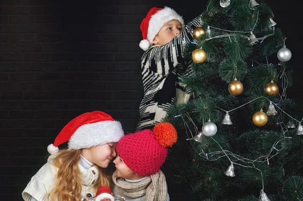 Kinderen versieren de kerstboom op de kamer — Stockfoto
