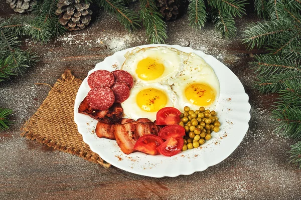 Christmas Breakfast-fried egg, green peas tomatoes, bacon and bread. — Stock Photo, Image