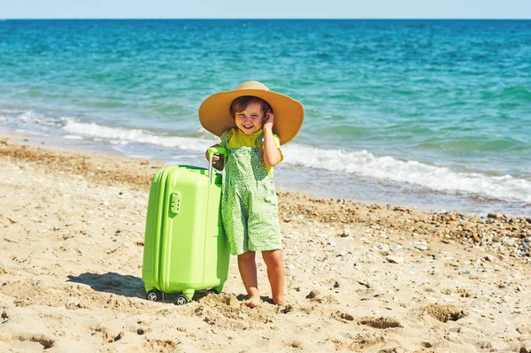 Ein Kind mit einem Koffer am Meer . — Stockfoto