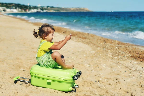 A gyermek egy bőröndöt a tengerparton . — Stock Fotó