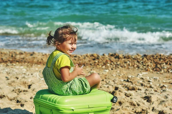 Ein Kind mit einem Koffer am Meer . — Stockfoto