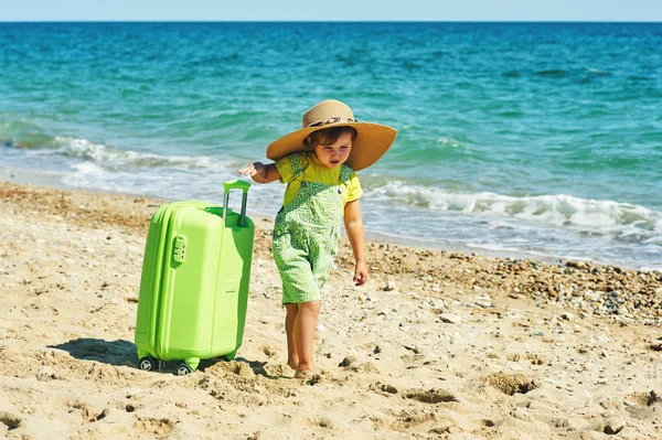 Ein Kind mit einem Koffer am Meer . — Stockfoto