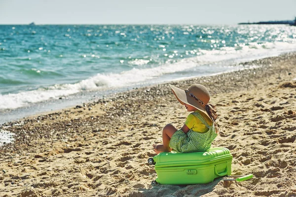 Ein Kind mit einem Koffer am Meer . — Stockfoto