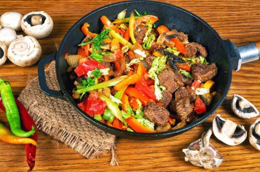 ahşap bir masa üzerinde sebze ile kızarmış et