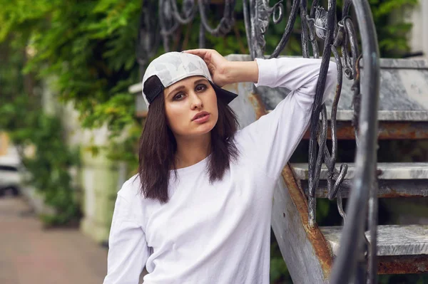 Young woman in casual clothes posing on a city street .The concept of easy casual wear .