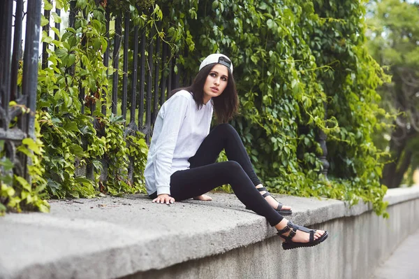 Young woman in casual clothes posing on a city street .The concept of easy casual wear .