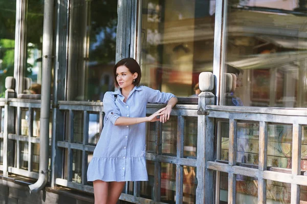 Young woman in casual clothes posing on a city street .The concept of easy casual wear .