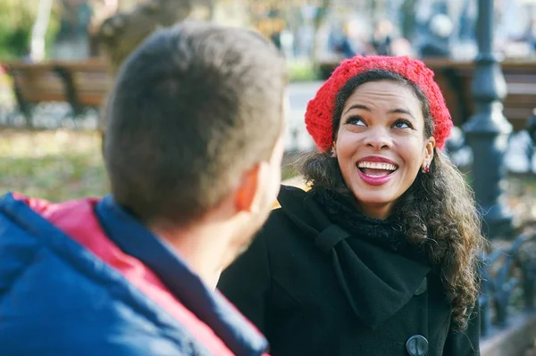 黑人女孩和白人男子坐在城市公园里谈话 — 图库照片