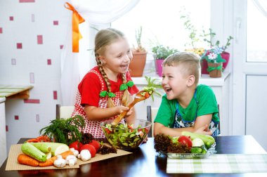 Eğlenceli çocuk salata sebze hazırlamak. Mutlu çocuklar mutfakta. Sağlıklı Vejetaryen beslenme kavramı