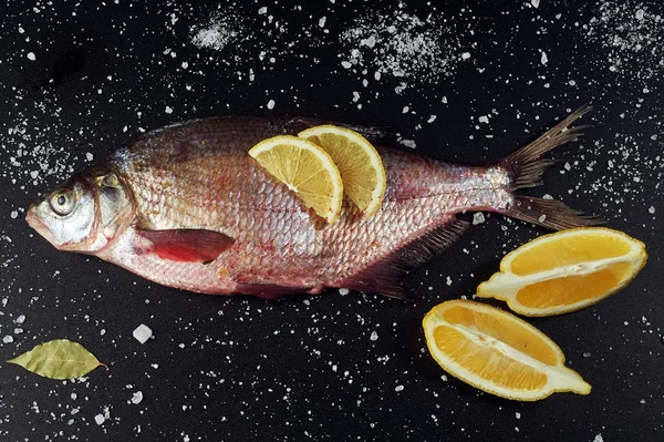 Fresh fish. River fish and ingredients for cooking on a dark background. The view from the top