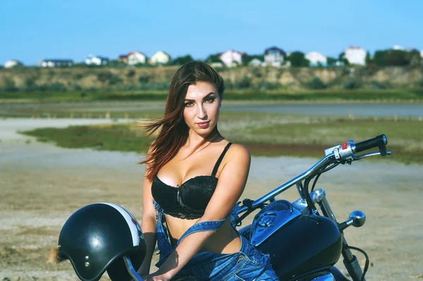 young redhead woman in bikini posing on a motorcycle