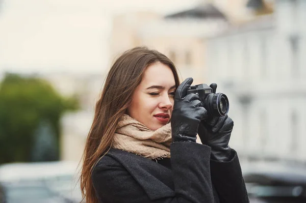 Young woman on a city street with a camera