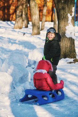 soğuk bir günde çocuk kızak kardeş üzerinde rulo