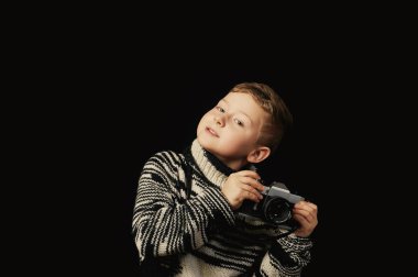 Koyu arka plan üzerinde Studio kamera ile güzel çocuk