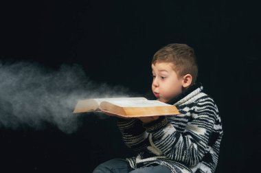 Yakışıklı çocuk elinde sihirli kitap tutar.