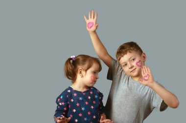 Kız ve erkek kardeşim yüz ve eller üzerinde boyalı yürekleri. Mutlu bir aile