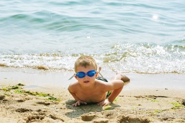 Sahilde yalan dinlenme yüzme için gözlüklü çocuk