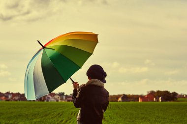 Çocuk bir parlak renkli şemsiye ile sahada. Doğa çocuk sahiptir