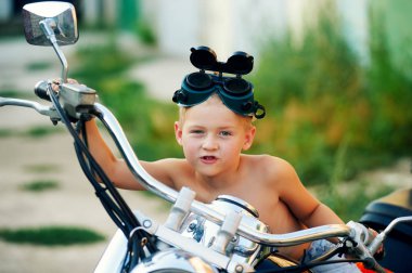 Babasının motosiklet üzerinde oynama ufaklık. Bir motorcu olmak rüya