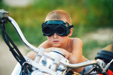 Babasının motosiklet üzerinde oynama ufaklık. Bir motorcu olmak rüya