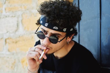 genç bir adam sigara içiyor.