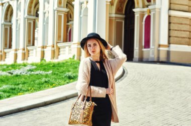 yakın çekim portre genç güzel şık kadının sokakta poz. Sokaklarda şapkalı şık bir model. Kadın moda