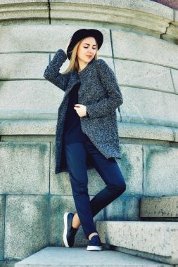 yakın çekim portre genç güzel şık kadının sokakta poz. Sokaklarda şapkalı şık bir model. Kadın moda