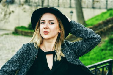 yakın çekim portre genç güzel şık kadının sokakta poz. Sokaklarda şapkalı şık bir model. Kadın moda