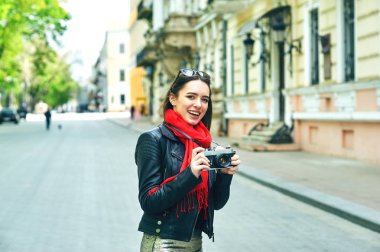 Genç kadın şık giysiler ve Avrupa kenti sokaklarında bir kamera