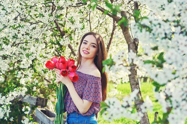 young woman with tulips in a blossoming Park