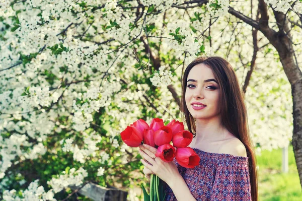 young woman with tulips in a blossoming Park