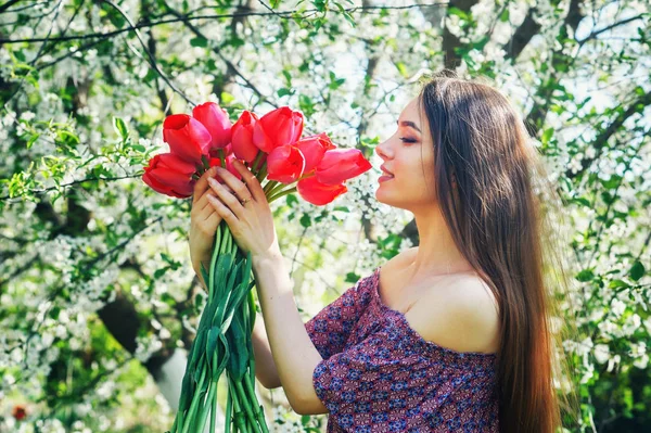 young woman with tulips in a blossoming Park