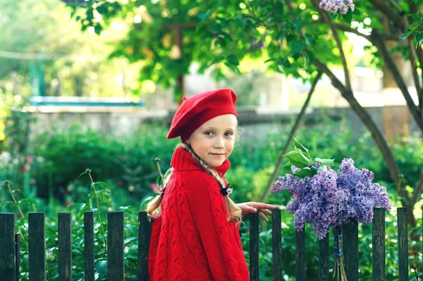 ライラックの花束を持つ美しい少女 ライラックの手で保持している赤いセーター ベレー帽の少女 — ストック写真