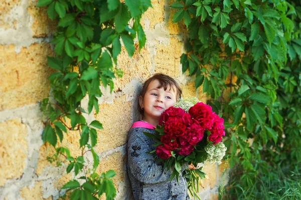 Маленькая Девочка Держит Букет Цветов Ребенок Пионами Кирпичной Стены — стоковое фото