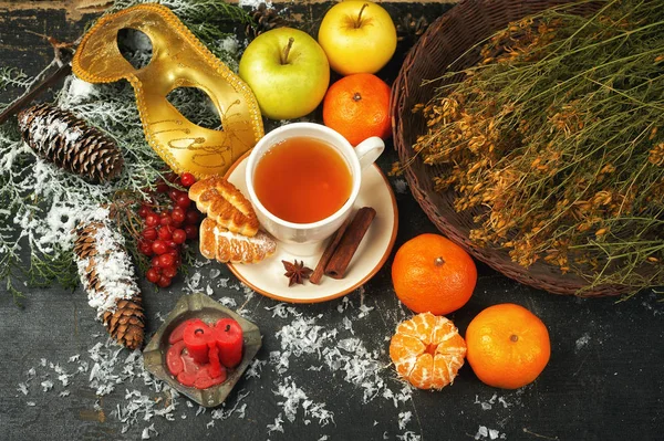 A Cup of hot tea with fruits and herbs, a traditional drink for winter time. Christmas composition