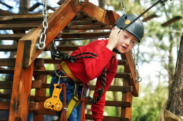 Little boy in climbing gear, active children's outdoor recreation
