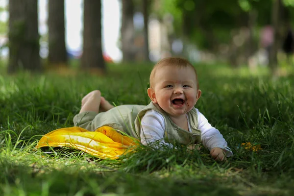 Μωρό Βρίσκεται Στο Πράσινο Γρασίδι Μια Ηλιόλουστη Μέρα Και Χαρούμενα — Φωτογραφία Αρχείου