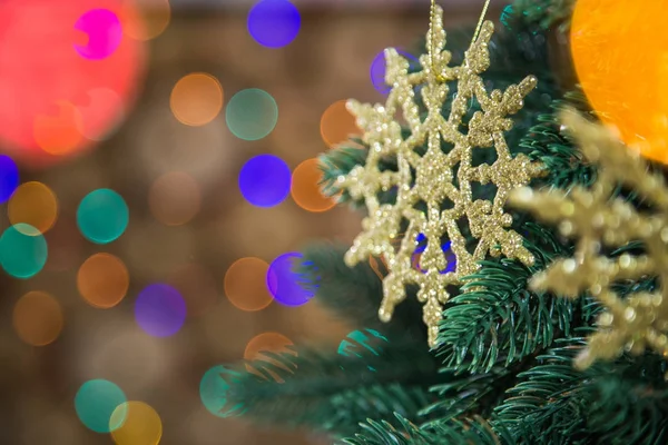 Flocons de neige ronds dorés accrochés au sapin de Noël vert — Photo